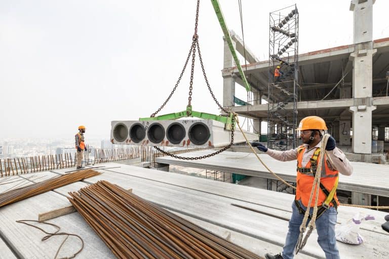 Installing a precast hollow core slab at Aurobindo's construction site in Hyderabad, India