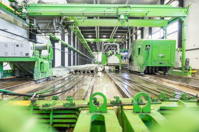 Hollow core slab production equipment in action at a precast floor slab plant.
