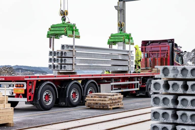 Lifting hollow core slabs from a precast element stockyard to a truck, ready to be delivered to the construction site.